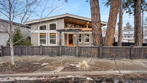 A two-story house with a wooden deck, a fenced yard, and large trees. - Dwell 30 Day Minimum- Modern & Peaceful, Walk to Old Mill, New and Lovely, AC (Bend)
