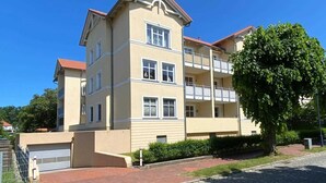 A multi-story residential building with a beige facade, balconies, and a red-tiled roof. - Vacation apartment Seeadler 1 (Graal-Müritz)