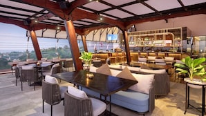A rooftop bar with outdoor seating, a bar area, and a view of the cityscape. - Hotel Aruss Semarang (Semarang)