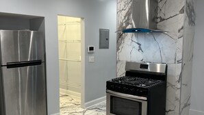 Una cocina moderna con un refrigerador de acero inoxidable, una estufa a gas y un horno.