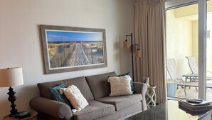 A modern living room with a sofa, a glass coffee table, and a painting on the wall. - 2BR/2BA-Sleeps 6
Seascape Condo at Miramar Beach (Destin)