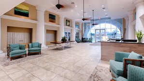 A spacious lobby with a reception desk, seating area, and large windows offering a view of the city. - 2BR/2BA-Sleeps 6
Seascape Condo at Miramar Beach (Destin)
