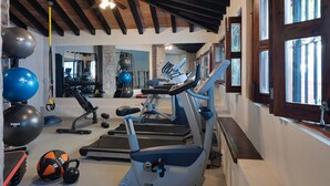 Un gimnasio con cintas de correr, balones de ejercicio y pesas.