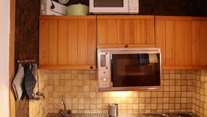 A kitchen with wooden cabinets, a microwave, a Bosch dishwasher, and a stainless steel sink.