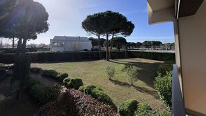 A view of a well-maintained garden with neatly trimmed hedges and a few trees, a modern building in the background, and a clear sky. - Cozy Studio Cabin with Terrace & Parking, 4 Sleeps, Near Beach, Le Grau-du-Roi (Le Grau-du-Roi)