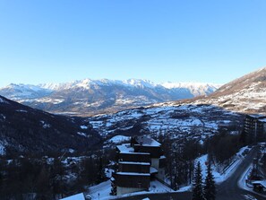 Uma pousada na montanha com vista para picos cobertos de neve.