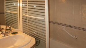 Une salle de bain avec un lavabo, un miroir et une douche.