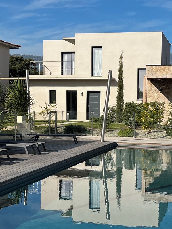 A modern two-story house with a swimming pool, outdoor furniture, and a stone wall. - VILLA U SANDA 3 minutes from the beach (Lecci)