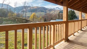 Una terraza de madera con vistas a un paisaje montañoso.