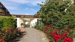 Un sentiero conduce a un edificio con un'insegna che recita 'Cafe Shop FIP - Ferienpark'.