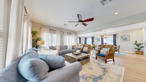 A spacious living room with a gray sofa, a wooden coffee table, and a patterned rug. - Shared Pool, Boardwalk to Beach and Golf Cart Included (Port Aransas)