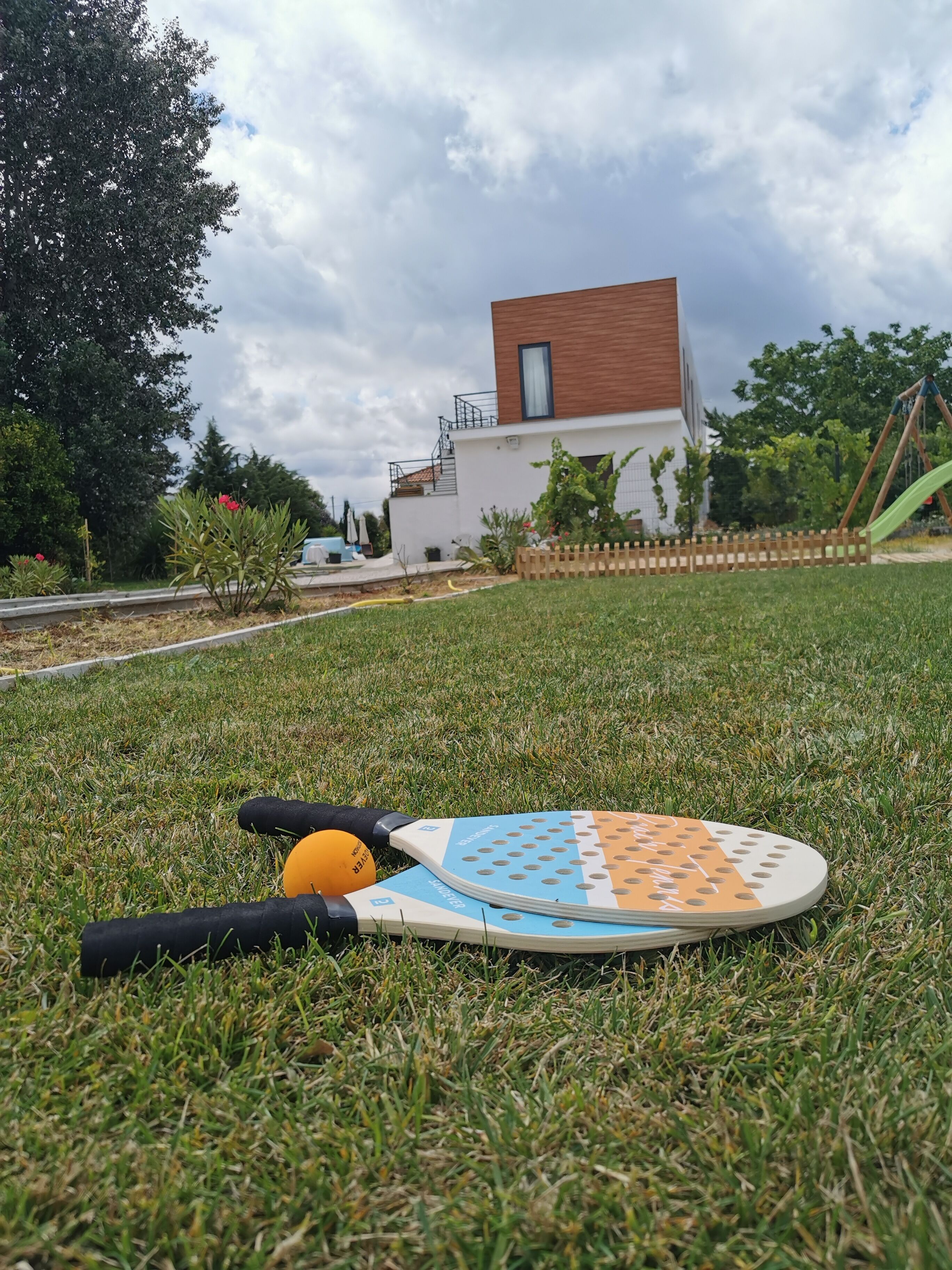 A badminton court with a net, shuttlecock, and rackets on the grass.