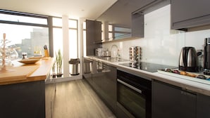 Een moderne keuken met roestvrijstalen apparatuur, een groot raam en uitzicht op de stad.