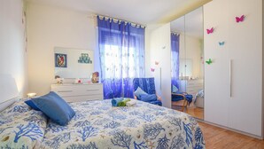 A bedroom with a bed, a dresser, a chair, and a mirror. - Pet friendly apartment in Follonica with WiFi (Follonica)