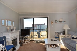 Cozy living room with a fireplace, TV, and comfortable seating area, offering a city view.