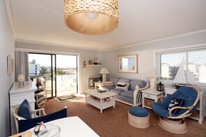 Relax in this stylish living room with a sofa, chair, and TV, offering a view of the city.