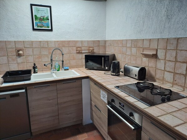 A compact kitchen with a sink, microwave, toaster, and stove. - La Chaumière de Chabine (OIZON)