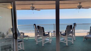 A balcony with white chairs, a table, and a view of the ocean. - Stylish, cozy 2 bedroom luxury oceanfront condo with free WiFi, an outdoor pool, and a stunning ocean view from a covered balcony and only steps from the beach in midtown! (Ocean City)