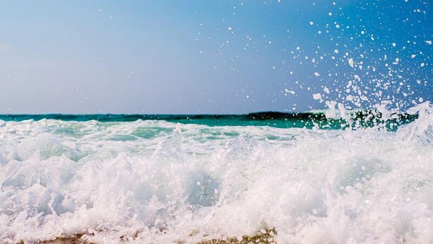 A beach with waves crashing onto the shore. - Stylish, cozy 2 bedroom luxury oceanfront condo with free WiFi, an outdoor pool, and a stunning ocean view from a covered balcony and only steps from the beach in midtown! (Ocean City)