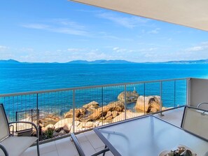 Un balcon avec vue sur la mer et la côte rocheuse.