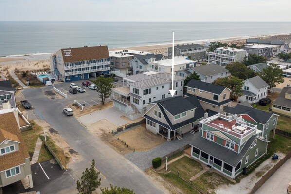 Zona residencial costera con casas, un hotel y una playa al fondo.