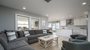 A modern living room with a grey sofa, a coffee table, and grey armchairs. - RENOVATED IN 2024, OCEAN BLOCK CHARMER - 12 CLAYTON ST,  DEWEY BEACH, DE (Dewey Beach)