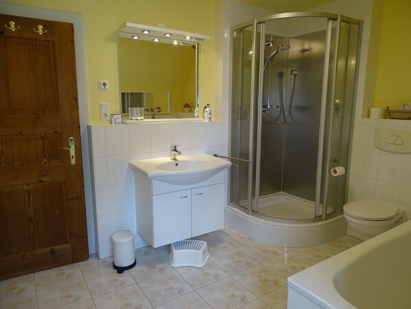 A bathroom with a wooden door, a sink, a glass shower enclosure, and a toilet. - Vacation home in the forest near the Rennstein (Georgenthal/Thüringer Wald)