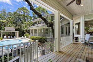 A covered outdoor deck with a pool, lounge chairs, and a pergola. - Pristine 4th row beach home with gorgeous updates and private pool & spa! (Hilton Head Island)