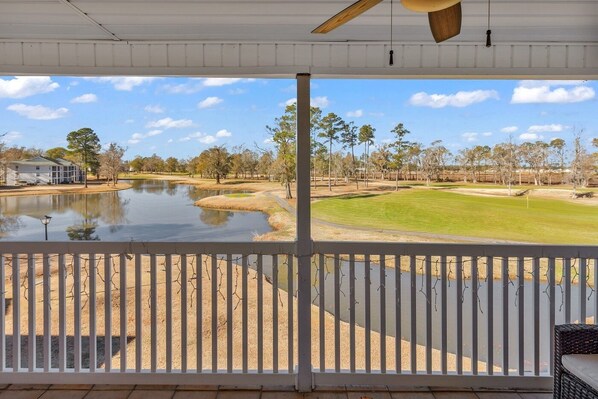 A covered porch with a view of a golf course and a body of water. - Beautiful and Peaceful Golf Condo in River Oaks. Less than 5 miles to beach! (Myrtle Beach)