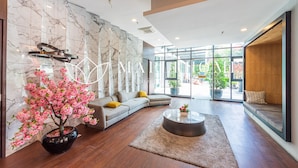 A modern hotel lobby with a marble wall, a large window, a sofa, a coffee table, and a potted plant. - Vista Premier Suites Genting Highlands (Genting Highlands)