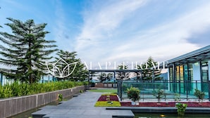 A modern building with a glass facade, a water feature, and a garden area with various plants. - Vista Premier Suites Genting Highlands (Genting Highlands)