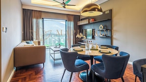 A modern dining area with a round table, blue chairs, and a ceiling fan. - Vista Premier Suites Genting Highlands (Genting Highlands)
