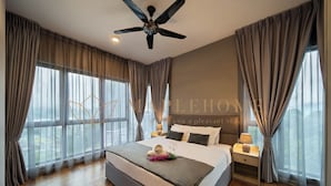 A modern hotel room with a large bed, a ceiling fan, and a view of the city. - Vista Premier Suites Genting Highlands (Genting Highlands)