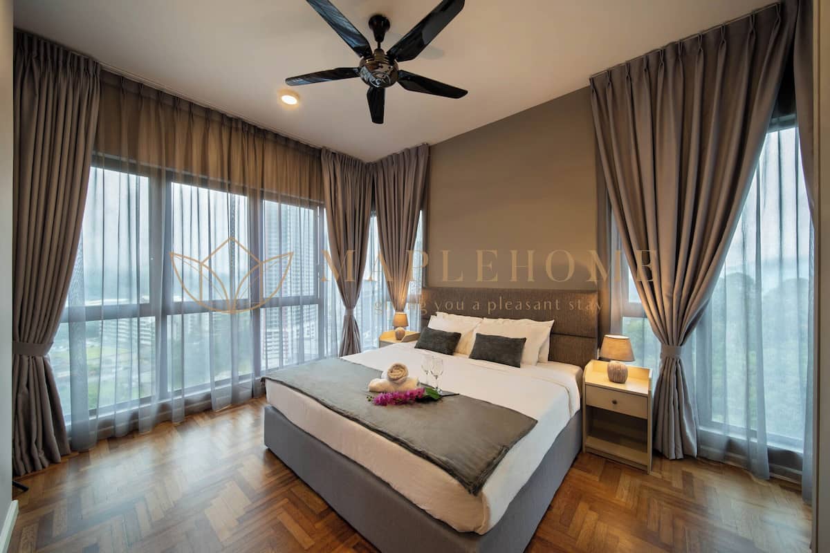 A modern hotel room with a large bed, a ceiling fan, and a view of the city.