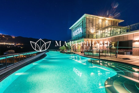 Una piscina al aire libre, sillones reclinables de piscina