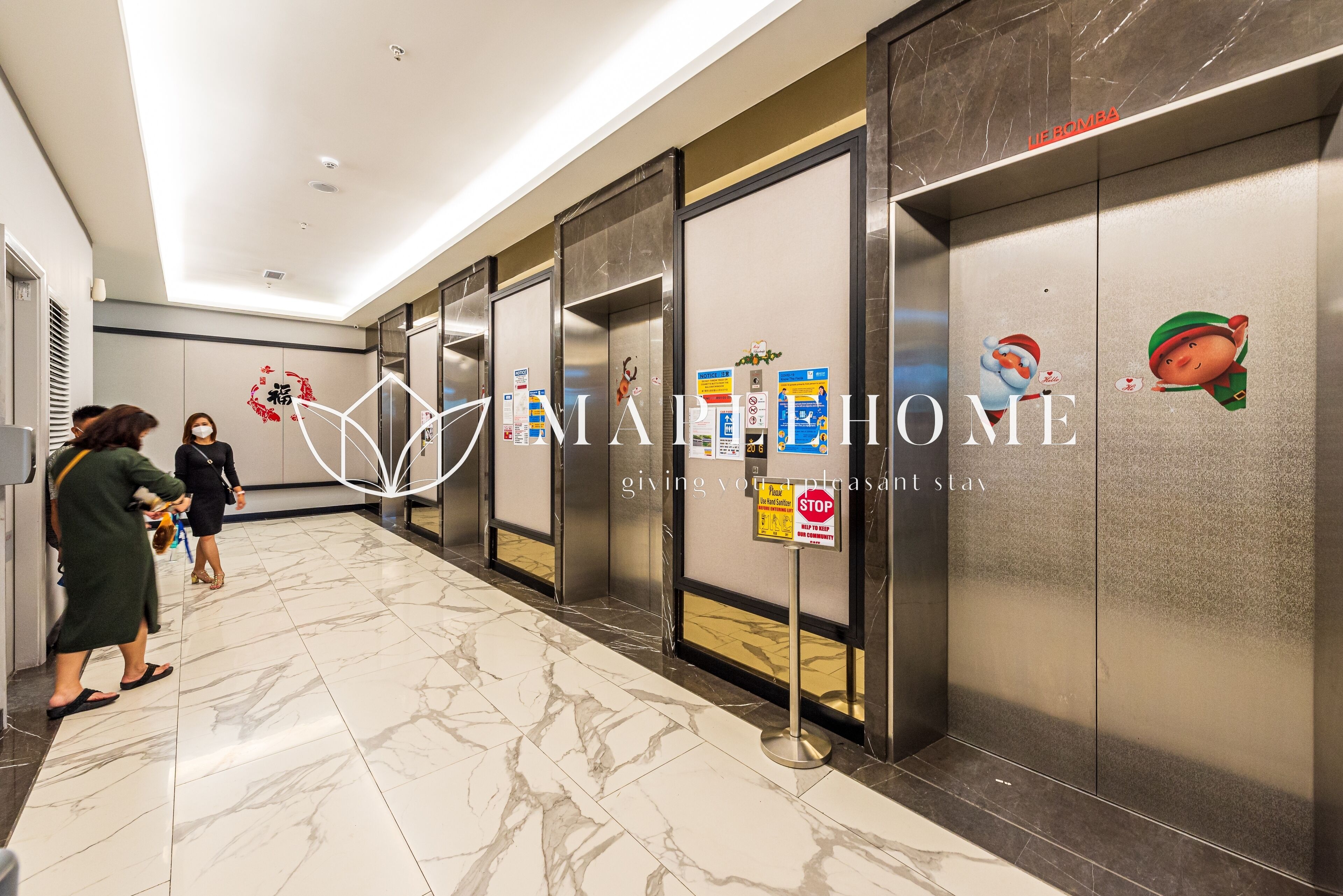 A hotel corridor with marble flooring, elevators, and a 'No Smoking' sign.
