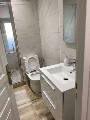 Une salle de bain avec des toilettes, un lavabo et un miroir.