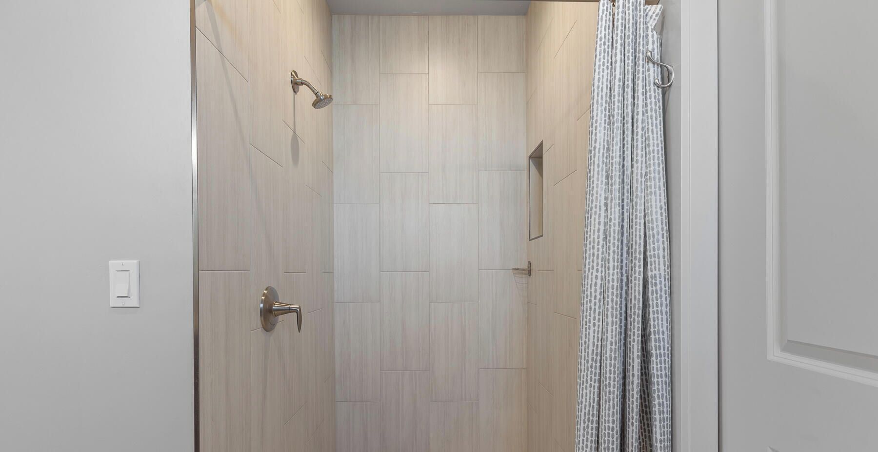 A bathroom with a shower, a toilet, and a sink.