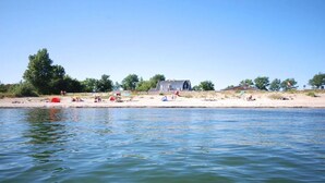 A beach with tents and a house by the water. - Strandhaus-Fehmarn, port side, sea view and beach on the doorstep (Fehmarn)