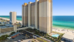 Ein Hochhaus-Hotel mit mehreren Etagen, einer Tiefgarage und Blick auf den Strand.