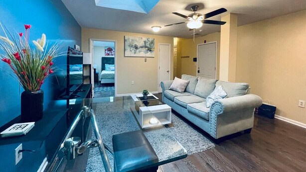 A modern living room with a sofa, coffee table, and a dining area with a glass table. - Cozy 1BD Apt @Magic Garden in Center City (Philadelphia)