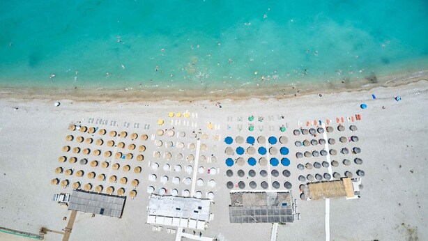Vue aérienne d’une plage avec des rangées d’espaces de sièges circulaires et un bâtiment.
