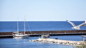 Ein Yachthafen mit einer vor Anker liegenden Segelyacht, einer Anlegestelle und einem fliegenden Möwe.