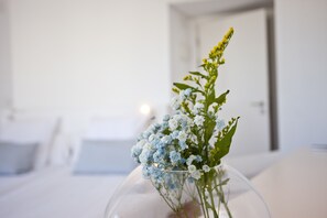A clear view of a room with a bed, a bedside table, and a vase with flowers. - Galaxia Boutique Hotel (Santa Margalida)