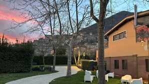 A courtyard with a gravel path, white chairs, and trees. - Villa Grancassa (San Donato Val Di Comino)