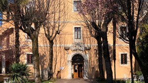 A building with a central entrance, flanked by trees and a paved walkway. - Villa Grancassa (San Donato Val Di Comino)