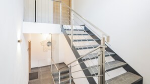 A staircase with a metal handrail and wooden steps, leading to an upper floor. - Fantastic luxury apartment in Salzburg's ski paradise (Mauterndorf)