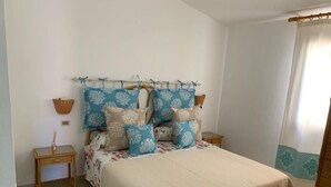 A bedroom with a bed, nightstands, and a window with curtains.