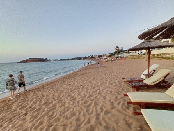 Ranta lähistöllä, aurinkotuoleja, rantapyyhkeitä