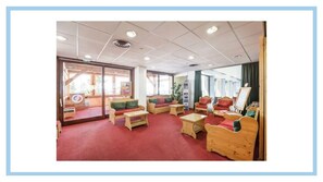 A room with wooden furniture, a red carpet, and large windows. - Tignes Val Claret 2 apartments with swimming pool and panoramic view (Tignes)
